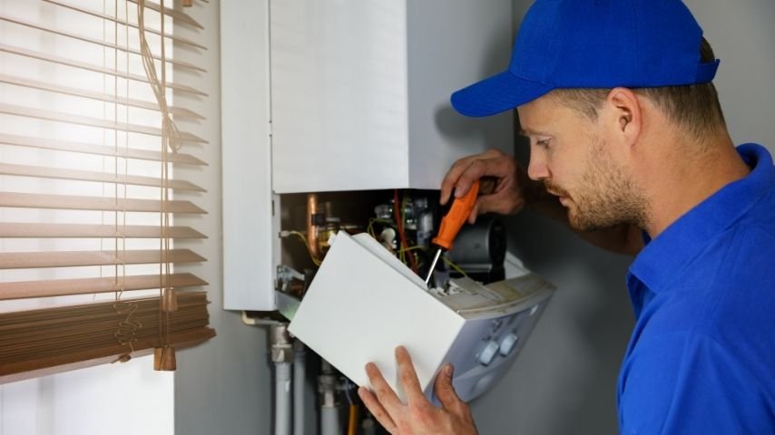 Engineer servicing a wall-mounted boiler